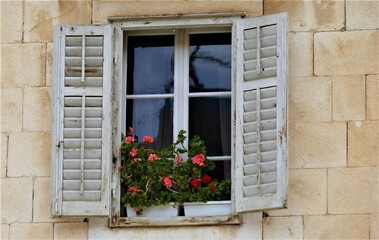 Fototapeta na wymiar White vintage window with flowers mediterranean style
