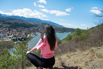Fototapeta na wymiar Traveler woman standing high above a blue lake with stunning panoramic view .Traveling in the nature in Bulgaria 