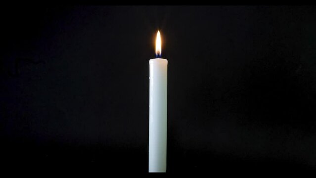 Vela blanca consumi&eacute;ndose a c&aacute;mara r&aacute;pida en fondo negro