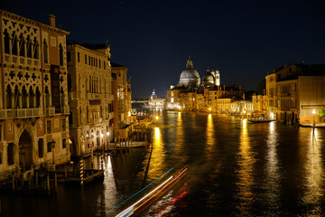 Obraz premium Venice, Italy: Night view of Venice Grand Canal with boats and Santa Maria della Salute church on sunset from Ponte dell'Accademia bridge. Venice, Italy
