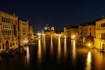 Venice, Italy: Night view of Venice Grand Canal with boats and Santa Maria della Salute church on sunset from Ponte dell'Accademia bridge. Venice, Italy