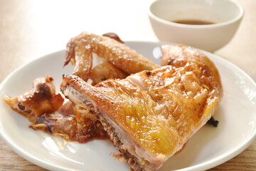 roasted chop chicken wing and leg on plate dipping with spicy sauce