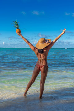 Dominican Republic of Punta Cana, a girl in a hat on the ocean with turquoise water and palm trees.