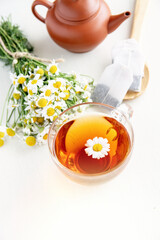  cup of herbal chamomile tea and fresh chamomile, camomile flowers	