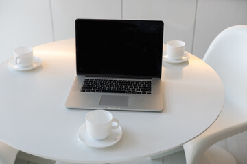 laptop on table with cups