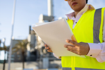 Anonymous female engineer in uniform on construction site