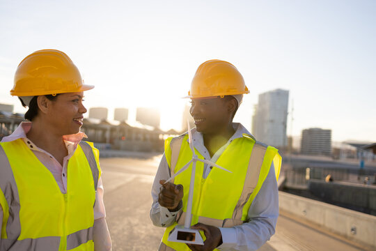Black engineers with wind turbine on construction site