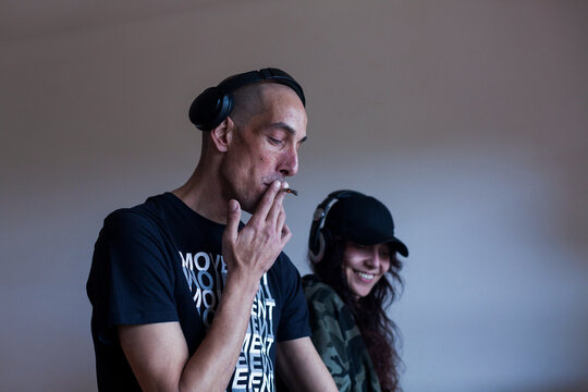 Male and female DJs in headphones in room