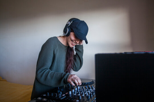 Female DJ using mixing console at home
