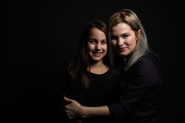 a little girl with her mother is praying while hugging