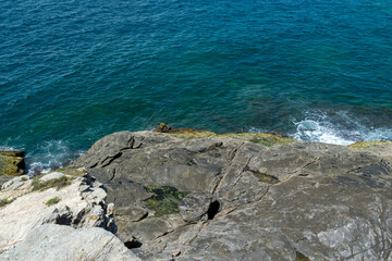 Top view of the beautiful beach of Conchas, near the city of Cabo Frio, with blue sea around and large rocks by the sea.