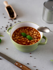 Baked Beans in tomato sauce in a plate against a grey background. Food. Food background