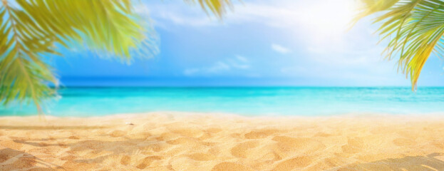 Beautiful wide panorama of a paradise beach with golden sand and palm leaves in blur. Summer banner.