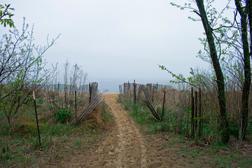 Sandy walkway to Cliffwood Beach flanked by a wooden fence on a foggy spring morning -04