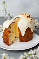 Piece of Easter cake on plate decorated with spring flower branches
