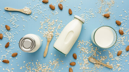 Milch Alternativen aus Mandel, Hafer und Reis in Glasflaschen auf einem blauen Tisch. Draufsicht. 