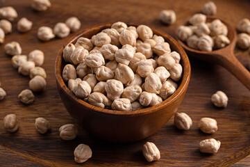 Chick pea uncooked beens. Studio shoot on wooden background. Beans spread on rustic scene. 45 degree shoot.
