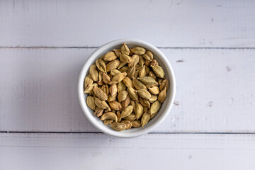 Cardamon seeds bowl. Studio shoot isolated on light background. Up view shoot.