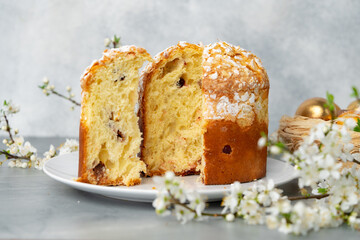 Cut Easter cake on plate decorated with spring flower branches