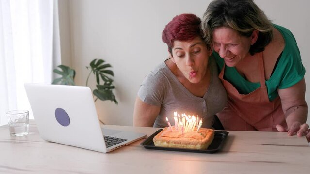 Senior gay lesbian couple birthday party - Wives celebrating anniversary with surprise cake at home - Lgbt family love