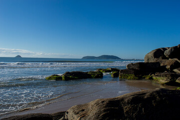 Ubatuba beach in southern San Francisco, with a calm sea, and a beautiful blue sky