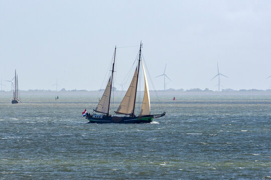 During a sunny but windy autumn day, several old sailing ships sail on the water of the Wadden Sea between Vlieland and the mainland near Harlingen, the Netherlands
