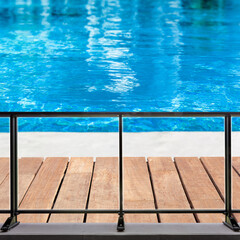 piscine à débordement  avec plage en bois et barrière de sécurité vitrée 