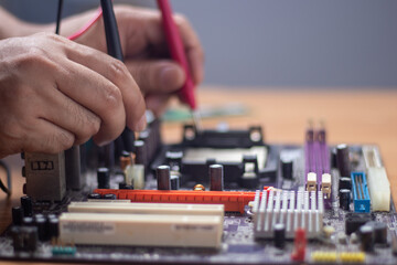 Fototapeta na wymiar Technician using tool to measure circuit board, check and repair