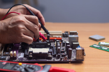 Fototapeta na wymiar Technician using tool to measure circuit board, check and repair