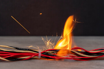 Ignition and fire in electrical wires on a dark background. A short circuit in the electrical...
