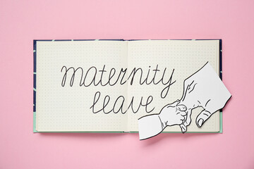 Notebook with phrase Maternity Leave and paper cutout of hands on pink background, top view
