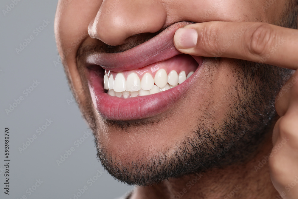 Wall mural man showing healthy gums on grey background, closeup