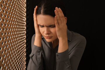Repentant woman during confession near wooden partition in booth