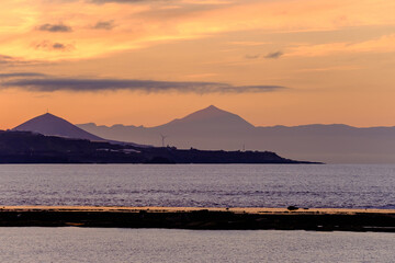 Beautiful view of Teide volcano and the island Tenerife from Las Canteras beach in Las Palmas de Gran Canaria, Spain at sunset.