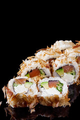 sushi roll with salmon cream cheese tuna avocado and cucumber on a black mirror background