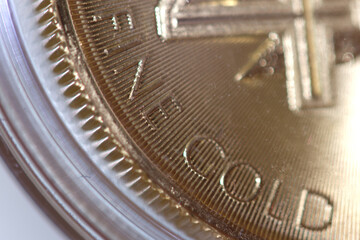 Macro Photo of a Gold Coin, selective focus on Fine Gold description. 