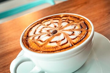 Delicious cappuccino with beautiful design and coffee bean