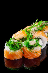 sushi roll with cream cheese philadelphia salmon cucumber chukka on a black mirror background