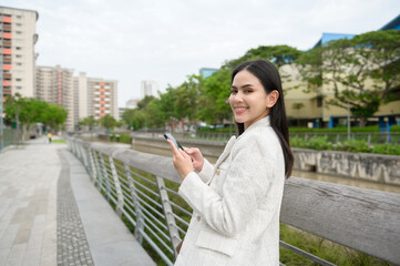 Fototapeta premium A young businesswoman is working in modern city downtown of Singapore