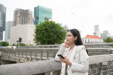 A young businesswoman is working in modern city downtown of Singapore