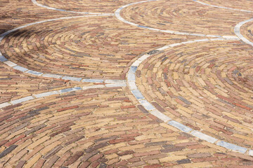 Fototapeta na wymiar Red cobblestones arranged in a round with a white border. Floor background