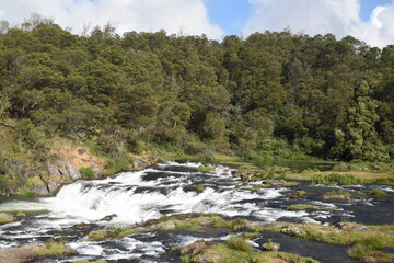River flowing with green hills and blue sky