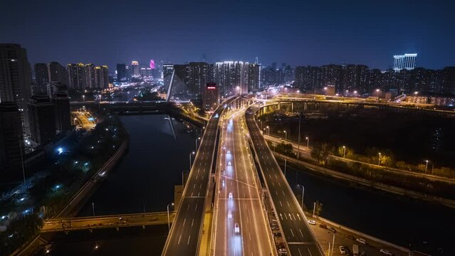 Drone hyper lapse of a bridge with cars and skyscrapers in the background at night