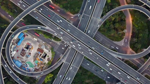 Aerial video of cars passing at a roundabout surrounded by tall modern buildings