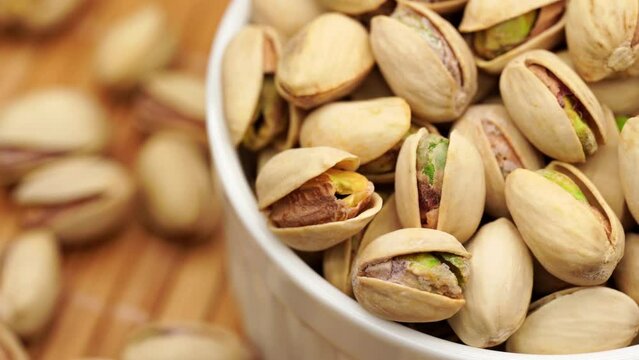 Salted Pistachios for Beer, Macro, Spin. Isolated Background of a Beer Snack of Salted Pistachio Nuts. Healthy Delicious Pistachios. Salted roasted pistachio macro, rotation