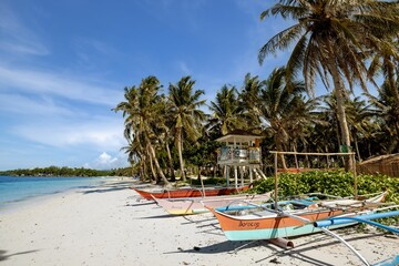 Scenic view of boats on a sandy beach surrounded by beautiful palm trees in Maldives