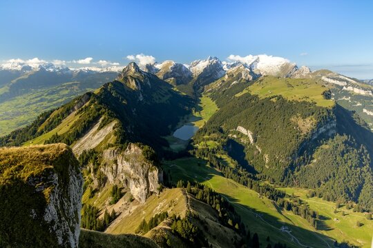 Breathtaking view of evergreen mountains surrounding a tranquil lake against a blue sky