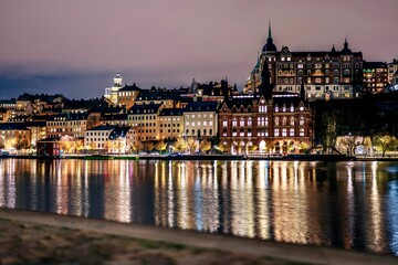 Fototapeta na wymiar The Stockholm skyline, featuring illuminated buildings and their reflections in the dark water