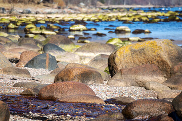 A rock in the water with the tide coming in.