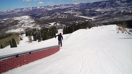 Male skier rail slide spring time at snowmass Colorado